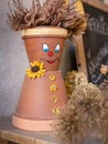 Puppet made of flowerpots and straw sitting on a board Royalty Free Stock Photo