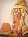 Puppet made of flowerpots and straw sitting on a board Royalty Free Stock Photo