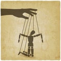 Puppet marionette on ropes is broken man on vintage background