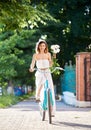 Puppet woman rides a vintage bicycle with bouquet of peonies Royalty Free Stock Photo