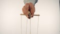 The puppeteer& x27;s hand controls the puppet with a wooden manipulator and strings. The marionettist controls and pulls Royalty Free Stock Photo
