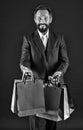 Purchase concept. Happy man with purchase in shopping bags. Bearded man smile with purchase. Purchase order, black and