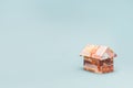 Purchase of housing. Close up of paper origami house made of Russian rubles. Light blue background with copy space. The