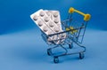Purchase of medicines. Small cart with tablets in the package.