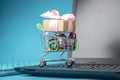 Daily purchases and gifts in the shopping cart on the laptop keyboard on a blue background. Shopping in online stores Royalty Free Stock Photo