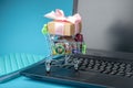 Daily purchases and gifts in the shopping cart on the laptop keyboard. Concept of shopping in online stores Royalty Free Stock Photo