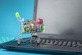 Daily purchases in the shopping cart on the laptop keyboard on a blue background. Concept of shopping in online stores Royalty Free Stock Photo