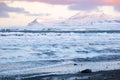 Pure blue ocean water at sunset, Ocean coastline with mountains, Winter landscape with snow, clouds and stormy sea Royalty Free Stock Photo