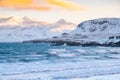 Pure blue ocean water at sunset, Ocean coastline with mountains, Winter landscape with snow, clouds and stormy sea Royalty Free Stock Photo