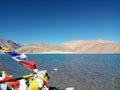 Pure Blue Pangong tso (Lake) and colorful religious flags Royalty Free Stock Photo
