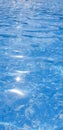Pure blue water in the swimming pool with light reflections. Top view aerial. Vertical Royalty Free Stock Photo