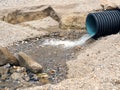 Pure clear water flows from a wide corrugated pipe. Eco-friendly background with clear water