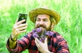 Pure emotions. summer selfie with lilac on phone. ranch hipster has long healthy beard. flower in hair. relaxed farmer