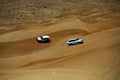 White 4WD SUVs Driving on Desert Dunes in Dubai Royalty Free Stock Photo