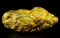 Pure gold ore on black background. Big gold nugget Royalty Free Stock Photo