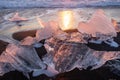 Pure Ice Shining on Black Volcanic Sand at Sunset. Icebergs from Glacier in Sun Rays. Clear Ice in Ocean Waves. Famous Royalty Free Stock Photo