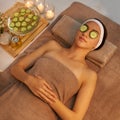 Pure indulgence. A beautiful young woman lying on a massage table at the spa with cucumer over her eyes.