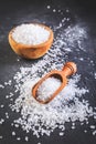 Pure natural sea salt in wooden bowl and wooden spoon on black background Royalty Free Stock Photo