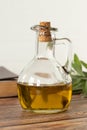 Pure olive oil in a glass jar, a closed Bible Book, and a green olive branch on a wooden table with white background Royalty Free Stock Photo