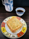 Pure red bean moon cake  served with a cup of tea in a round dish on a wooden background. Royalty Free Stock Photo