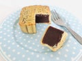 Pure Red Bean Paste moon cake with a portion cut out in blue plate and fork on marble background.