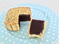 Pure Red Bean Paste moon cake with a portion cut out in a blue plate on a marble background. close up.