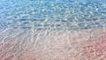 Pure transparent crystal sea water washes on pink sand