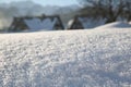 Pure untouched snow. Close-up. On the wavy surface, snowflakes sparkle in the sun..Village houses in the background Royalty Free Stock Photo