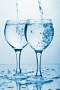 Pure water splashing into two glasses Royalty Free Stock Photo