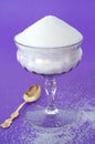 Pure White Granulated Sugar in a Vintage Glass on a Purple Background