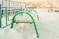 Pure white snow accumulates on a green bench in a winter sunny day Royalty Free Stock Photo