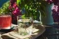 Purified aesthetic outdoor table with pure glass of water, compote and flowers. Aesthetic breakfast in the garden, water