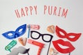 Purim celebration concept with carnival mask and photo props on white background.