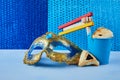 Purim celebration concept with hamantashen cookies, Purim mask and toy noisemaker on blue background