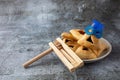 Purim celebration concept with hamantashen cookies, Purim mask and toy noisemaker on grey background