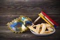 Purim celebration concept with hamantashen cookies, Purim mask and toy noisemaker on wooden background