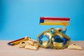 Purim celebration concept with hamantashen cookies, Purim mask and toy noisemaker on blue background