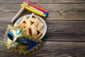Purim celebration concept with hamantashen cookies, Purim mask and toy noisemaker on wooden background