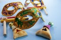 Purim celebration concept. Mask with hamantashen cookies and gragger. Jewish carnival background.