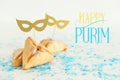 Purim celebration concept & x28;jewish carnival holiday& x29;. Traditional hamantaschen cookies with cute gold masks