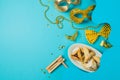 Purim holiday concept with carnival mask, noisemaker and hamantaschen cookies on blue background. Royalty Free Stock Photo