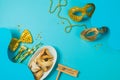 Purim holiday concept with carnival mask, noisemaker and hamantaschen cookies on blue background. Royalty Free Stock Photo