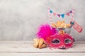 Purim holiday concept with hamantaschen cookies or hamans ears in bucket and carnival mask