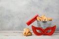 Purim holiday concept with hamantaschen cookies or hamans ears in bucket and carnival mask Royalty Free Stock Photo