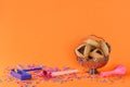 Purim holiday concept with hamantaschen cookies, balloon and noisemaker over joy orange color with confetti background. Royalty Free Stock Photo