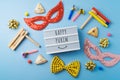 Purim holiday greeting card with carnival mask, noisemaker and hamantaschen cookies. Flat lay background Royalty Free Stock Photo