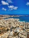 The purity of the elements. Open pit mine for mining of crushed stone. Deep blue sea. Endless sea with rocky coast covered with Royalty Free Stock Photo