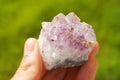 Purple amethyst gemstone from Brazil held in a hand