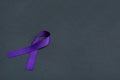 Purple awareness ribbon on black background, space for Royalty Free Stock Photo