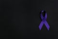 Purple awareness ribbon on black background, top view Royalty Free Stock Photo